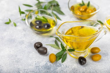 Doku arka planında bir şişe zeytinyağı. Zeytin dallı ve meyveli yağ şişesi. Mesaj için yer. kopyalama alanı. Yemek yağı ve salata sosu..