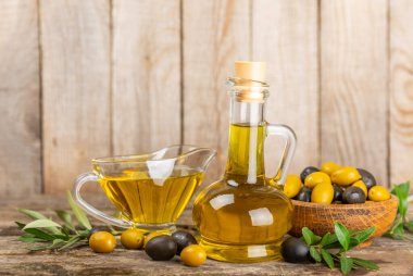 Doku arka planında bir şişe zeytinyağı. Zeytin dallı ve meyveli yağ şişesi. Mesaj için yer. kopyalama alanı. Yemek yağı ve salata sosu..