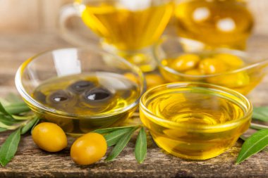 Doku arka planında bir şişe zeytinyağı. Zeytin dallı ve meyveli yağ şişesi. Mesaj için yer. kopyalama alanı. Yemek yağı ve salata sosu..