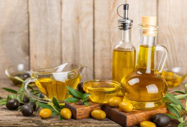 Doku arka planında bir şişe zeytinyağı. Zeytin dallı ve meyveli yağ şişesi. Mesaj için yer. kopyalama alanı. Yemek yağı ve salata sosu..