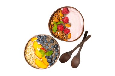 Beyaz arka planda yoğurt, taze badem, yaban mersini, ahududu, şeftali ve çilek içeren bir kase granola. Sağlıklı yiyecekler. dengeli kahvaltı.