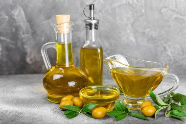Doku arka planında bir şişe zeytinyağı. Yağ şişesi ve dallı bir kase ve zeytin meyvesi. Mesaj için yer. kopyalama alanı. Yemek yağı ve salata sosu..