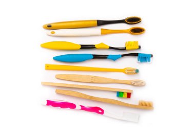 Elektrik, bambu ve beyaz arka planda izole edilmiş sıradan diş fırçaları. Ağız temizliği. Çevre. Taşıyıcıların önlenmesi. Dişçi arabası. Diş hekimliği ve çevre dostu yaşam tarzı kavramı.