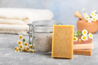 Ahşap bir masada papatya çiçekli doğal ev yapımı sabun. Doğal bitkisel yağlarla nemlendirici sabun yakın plan. Spa ve güzellik konsepti. Mesaj için yer. Uzayı kopyala. Fletley