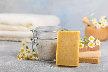 Ahşap bir masada papatya çiçekli doğal ev yapımı sabun. Doğal bitkisel yağlarla nemlendirici sabun yakın plan. Spa ve güzellik konsepti. Mesaj için yer. Uzayı kopyala. Fletley