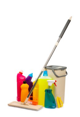 Beyaz arka planda izole edilmiş temizlik malzemeleriyle plastik paspas ve kova. İçinde çeşitli deterjanlar bulunan şişeler. Pencereler, yerler, tuvaletler ve tesisat malzemeleri için temizlik maddesi. Ev ve ofis temizliği.