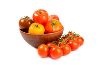 Beyaz arka planda izole edilmiş çeşitli renkli domatesler. Taze sarı, kırmızı, siyah, pembe ve kahverengi domatesler. Taze sebzeler. Vejetaryen. Yakın plan. Sağlıklı yiyecekler. Salata Malzemeleri.