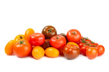 Beyaz arka planda izole edilmiş çeşitli renkli domatesler. Taze sarı, kırmızı, siyah, pembe ve kahverengi domatesler. Taze sebzeler. Vejetaryen. Yakın plan. Sağlıklı yiyecekler. Salata Malzemeleri.