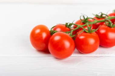 Doku arka planında domatesler. Mutfak masasında kiraz domatesleri. Organik sebzeler, hasat. Vejetaryen. Taze olgun domatesler. Boşluğu kopyala.