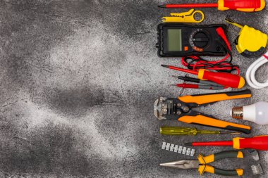 Mermer zemin üzerinde mermer arkaplan üzerinde elektrikli ekipman. Üst görünüm. Elektrik aracı seti. Çoklu metre, test cihazı, tornavida, kesiciler, koli bandı, lamba, mezura, mezura ve kablo..