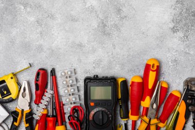 Mermer zemin üzerinde mermer arkaplan üzerinde elektrikli ekipman. Üst görünüm. Elektrik aracı seti. Çoklu metre, test cihazı, tornavida, kesiciler, koli bandı, lamba, mezura, mezura ve kablo..