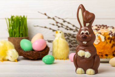 Açık dokuma masasında paskalya çikolatası tavşanı. Çikolatalı yumurta ve diğer tatlılar. Paskalya kutlaması. Paskalya tatlıları masada. Mesaj için yer. Boşluğu kopyala.