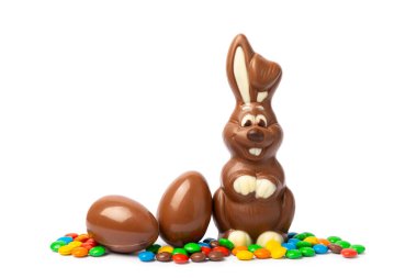 Beyaz arka planda izole edilmiş Paskalya çikolatalı tavşanı. Çikolatalı yumurta ve diğer tatlılar. Paskalya kutlaması. Paskalya tatlıları masada. Mesaj için yer. Boşluğu kopyala.