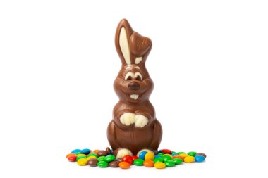 Beyaz arka planda izole edilmiş Paskalya çikolatalı tavşanı. Çikolatalı yumurta ve diğer tatlılar. Paskalya kutlaması. Paskalya tatlıları masada. Mesaj için yer. Boşluğu kopyala.