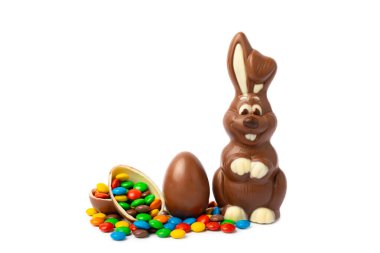 Beyaz arka planda izole edilmiş Paskalya çikolatalı tavşanı. Çikolatalı yumurta ve diğer tatlılar. Paskalya kutlaması. Paskalya tatlıları masada. Mesaj için yer. Boşluğu kopyala.