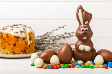 Açık dokuma masasında paskalya çikolatası tavşanı. Çikolatalı yumurta ve diğer tatlılar. Paskalya kutlaması. Paskalya tatlıları masada. Mesaj için yer. Boşluğu kopyala.