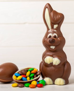 Açık dokuma masasında paskalya çikolatası tavşanı. Çikolatalı yumurta ve diğer tatlılar. Paskalya kutlaması. Paskalya tatlıları masada. Mesaj için yer. Boşluğu kopyala.