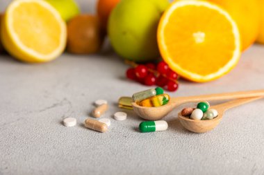 Vitaminler ve takviyeler. Ahşap bir kaşıkta çeşitli vitamin hapları. Taze ve sağlıklı meyveli Multivitaminler. Yiyecek takviyeleri. Düz yatıyordu. Metin için boşluk. Boşluğu kopyala
