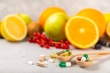 Vitaminler ve takviyeler. Ahşap bir kaşıkta çeşitli vitamin hapları. Taze ve sağlıklı meyveli Multivitaminler. Yiyecek takviyeleri. Düz yatıyordu. Metin için boşluk. Boşluğu kopyala