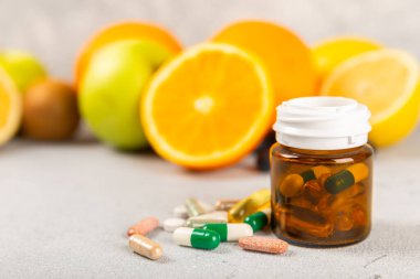 Vitaminler ve takviyeler. Arka planda bulunan bir kavanozdaki vitamin haplarının çeşitliliği. Taze ve sağlıklı meyveli multivitaminler. Yiyecek takviyeleri. Düz yatıyordu. Metin için boşluk. Boşluğu kopyala