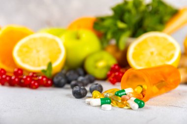 Vitaminler ve takviyeler. Arka planda bulunan bir kavanozdaki vitamin haplarının çeşitliliği. Taze ve sağlıklı meyveli multivitaminler. Yiyecek takviyeleri. Düz yatıyordu. Metin için boşluk. Boşluğu kopyala