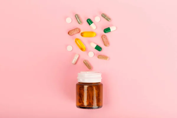 Vitamins and supplements. Variety of vitamin tablets in a jar on a texture background.Multivitamins with fresh and healthy fruits.Food supplements. Flat lay. Space for text.Copy space