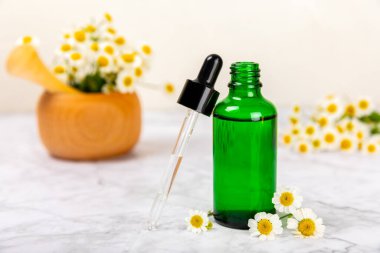 Eski ahşap arka planda papatya yağı bulunan cam şişe. Papatya çiçekleri, yaklaşın. Aromaterapi, spa ve bitkisel ilaç malzemeleri. Güzellik konsepti. Uzayı kopyala. Doğal Kozmetik