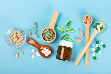 Vitaminler ve takviyeler. Kumaşlı arka planda kavanozda çeşitli vitamin hapları var. Her gün için bir multivitamin kompleksi. Besleyici takviyeler. Mesaj için yer. Boşluğu kopyala. Bağışıklık için vitaminler.