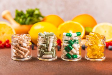 Vitaminler ve takviyeler. Kumaşlı arka planda kavanozda çeşitli vitamin hapları var. Her gün için bir multivitamin kompleksi. Besleyici takviyeler. Mesaj için yer. Boşluğu kopyala. Bağışıklık için vitaminler.