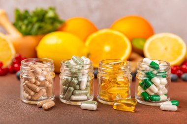 Vitaminler ve takviyeler. Kumaşlı arka planda kavanozda çeşitli vitamin hapları var. Her gün için bir multivitamin kompleksi. Besleyici takviyeler. Mesaj için yer. Boşluğu kopyala. Bağışıklık için vitaminler.