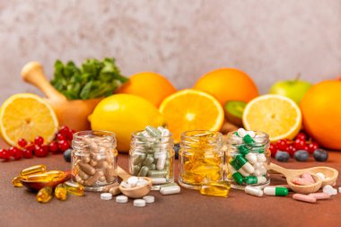 Vitaminler ve takviyeler. Kumaşlı arka planda kavanozda çeşitli vitamin hapları var. Her gün için bir multivitamin kompleksi. Besleyici takviyeler. Mesaj için yer. Boşluğu kopyala. Bağışıklık için vitaminler.