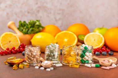 Vitamins and supplements. A variety of vitamin tablets in a jar on a textured background. A multivitamin complex for every day. Nutritional supplements.Place for text.Copy space.Vitamins for immunity clipart