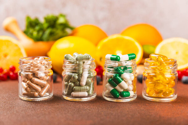 Vitamins and supplements. A variety of vitamin tablets in a jar on a textured background. A multivitamin complex for every day. Nutritional supplements.Place for text.Copy space.Vitamins for immunity