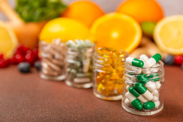 Vitamins and supplements. A variety of vitamin tablets in a jar on a textured background. A multivitamin complex for every day. Nutritional supplements.Place for text.Copy space.Vitamins for immunity