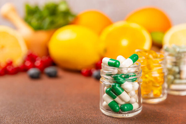 Vitamins and supplements. A variety of vitamin tablets in a jar on a textured background. A multivitamin complex for every day. Nutritional supplements.Place for text.Copy space.Vitamins for immunity