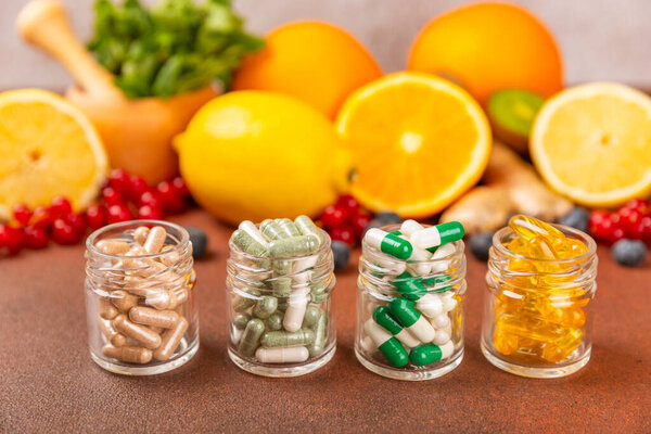Vitamins and supplements. A variety of vitamin tablets in a jar on a textured background. A multivitamin complex for every day. Nutritional supplements.Place for text.Copy space.Vitamins for immunity