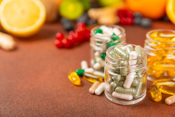 Vitamins and supplements. A variety of vitamin tablets in a jar on a textured background. A multivitamin complex for every day. Nutritional supplements.Place for text.Copy space.Vitamins for immunity