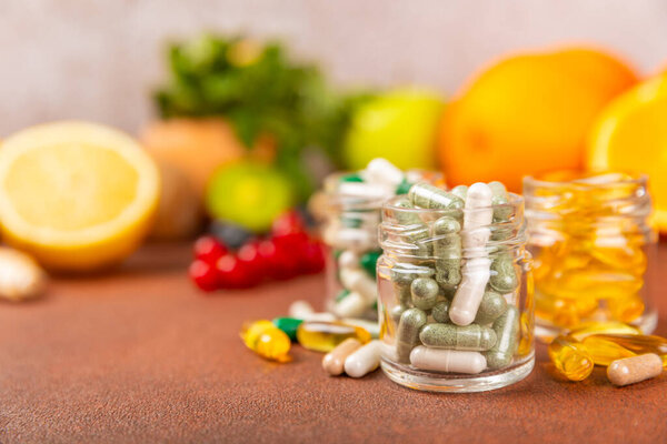 Vitamins and supplements. A variety of vitamin tablets in a jar on a textured background. A multivitamin complex for every day. Nutritional supplements.Place for text.Copy space.Vitamins for immunity