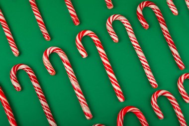 Şeker kamışı. Yeşil arka planda Noel şeker kamışı. Tatil tebrik kartı. Noel ve yeni yıl tatili kavramları. Kış. Düz görünüm, üst görünüm, boşluk kopyala.