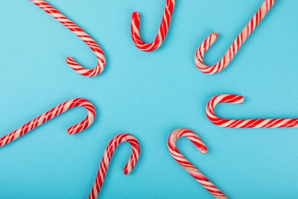 Candy cane.Christmas candy canes on a blue background. Holiday greeting card. Concept for Christmas and New Year holidays. Winter. Flatlay, top view, copy space.