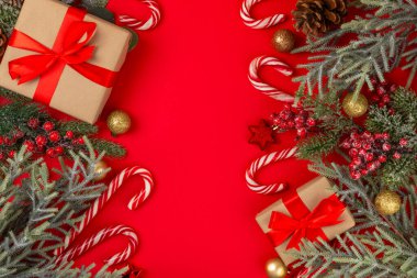Kırmızı arka planda Noel şekerleri. Tatil tebrik kartı. Noel ve yeni yıl tatili kavramları. Kış. Düz görünüm, üst görünüm, boşluk kopyala.
