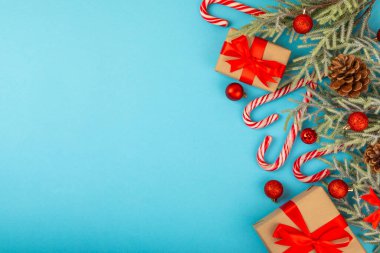 Noel şekeri. Şeker kamışı. Hediyeli Noel kompozisyonu. Mavi arka planda Noel ağacı süslemeleri. Noel ve yeni yıl tatili kavramları. Kış. Düz görünüm, üst görünüm, boşluk kopyala.