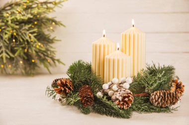 Doku arka planında mum olan bir Noel süsü. Yeni yıl ve Noel mumları. Sıcak ev dekorasyonu. Yanan mum ve Noel süsü. Noel ışıkları. Boşluğu kopyala. Tatil kavramı. 