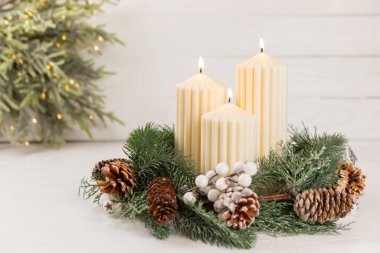 Doku arka planında mum olan bir Noel süsü. Yeni yıl ve Noel mumları. Sıcak ev dekorasyonu. Yanan mum ve Noel süsü. Noel ışıkları. Boşluğu kopyala. Tatil kavramı. 