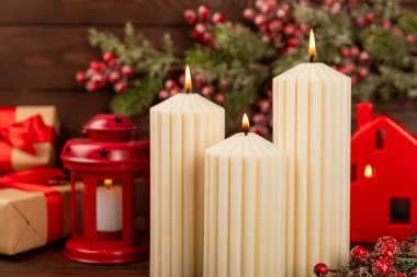 Doku arka planında mum olan bir Noel süsü. Yeni yıl ve Noel mumları. Sıcak ev dekorasyonu. Yanan mum ve Noel süsü. Noel ışıkları. Boşluğu kopyala. Tatil kavramı. 