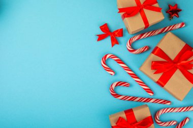 Noel şekeri. Şeker kamışı. Hediyeli Noel kompozisyonu. Mavi arka planda Noel ağacı süslemeleri. Noel ve yeni yıl tatili kavramları. Kış. Düz görünüm, üst görünüm, boşluk kopyala.