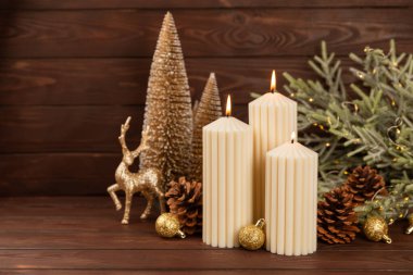 Doku arka planında mum olan bir Noel süsü. Yeni yıl ve Noel mumları. Sıcak ev dekorasyonu. Yanan mum ve Noel süsü. Noel ışıkları. Boşluğu kopyala. Tatil kavramı. 