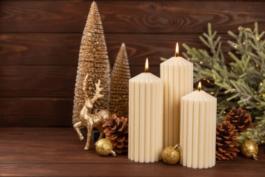 Doku arka planında mum olan bir Noel süsü. Yeni yıl ve Noel mumları. Sıcak ev dekorasyonu. Yanan mum ve Noel süsü. Noel ışıkları. Boşluğu kopyala. Tatil kavramı. 