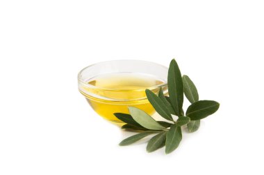 Bir kase taze zeytinyağı ve beyaz arka planda yapraklı zeytin. Cam kasede nefis zeytinyağı. Zeytin yağı şişesi.