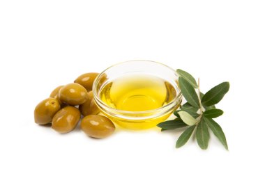 Bir kase taze zeytinyağı ve beyaz arka planda yapraklı zeytin. Cam kasede nefis zeytinyağı. Zeytin yağı şişesi.